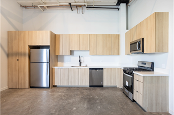 an empty kitchen with wooden cabinets and stainless steel appliances